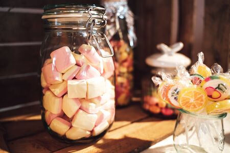 Candy bar. Close up of marshmallows in glass jar and bunch of lollipops. Celebration, party,...