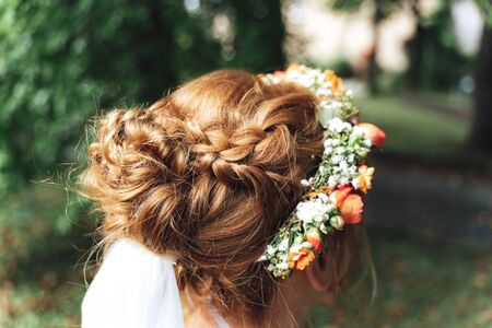 Bride hairstyle close up. Art of hairstylist with bridal flower headpiece. Outdoor background....