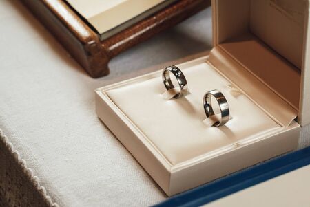 Wedding rings close up. Two pieces of jewelry in open beige box. Wedding accessories. Wedding day...