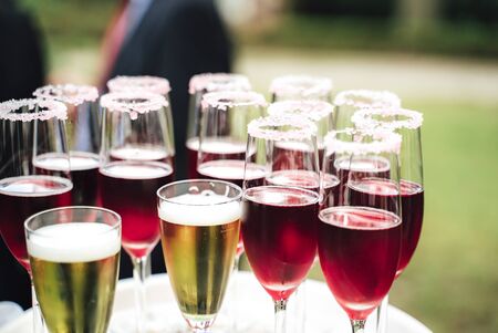 Several glasses with various colorful beverages. Alcoholic drinks in dewy glasses. Outdoor background. Celebration, birthday, party, wedding concept.の写真素材