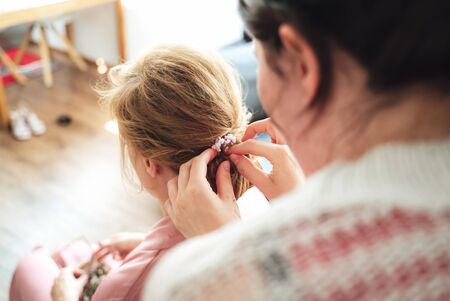 Female hairstylist making woman hairstyle. Rear view close up of hairdressers hands. Celebration, wedding day concept.の写真素材