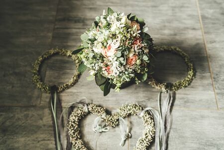 Bridal bouquet arranged with floral decoration. Flowers laying on gray tiled floor. Wedding day concept.の写真素材