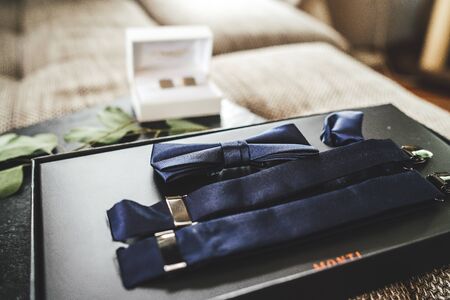 Dark blue bow tie and suspenders prepared for dressing. Elements of grooms clothes accessories. Wedding day concept.の写真素材
