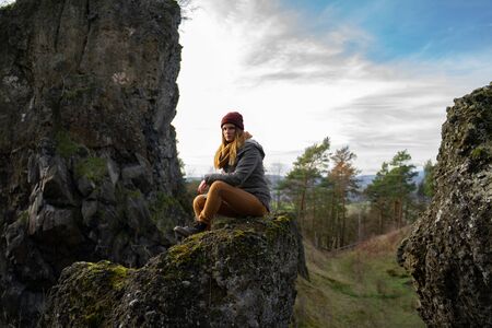 young hiker woman taking a rest on a rockの写真素材