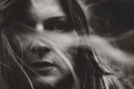 moody portrait of young woman and wind through hairの写真素材