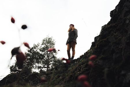 young woman wanderer stands on a mountain to restの写真素材