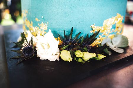 Closeup of wedding cake floral decoration. Various flowers at light blue round cake. Wedding day concept.の写真素材