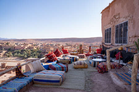 Furniture arranged on rooftop restaurant with village in background against clear skyの写真素材