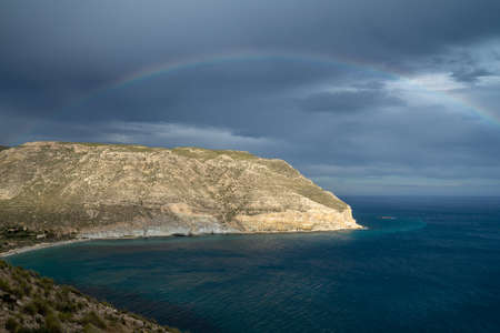 Scenic view of seascape by cliff against cloudy skyの写真素材