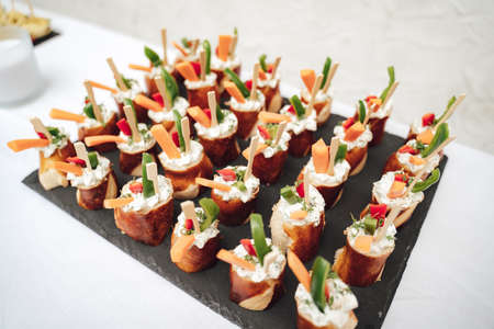 Close up of pretzel with vegetables and cream arranged on table at wedding partyの写真素材