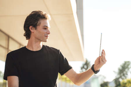 Caucasian young man having conference call using digital tablet outside officeの写真素材