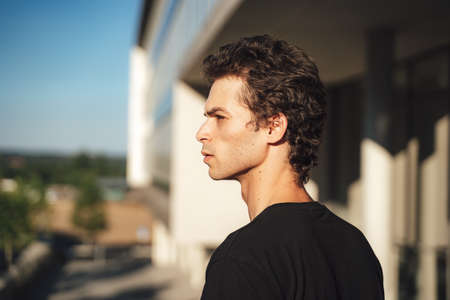 Close up of handsome Caucasian man looking away while standing outside officeの写真素材