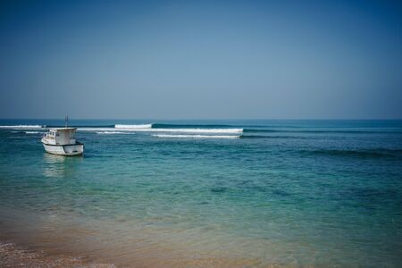 Lefthand point break wave on Hikkaduwa beach with crystal clear waterの写真素材