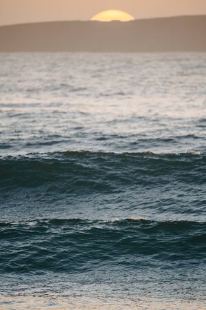 chilled out ocean atmosphere with the setting sun over peniche in the backgroundの写真素材