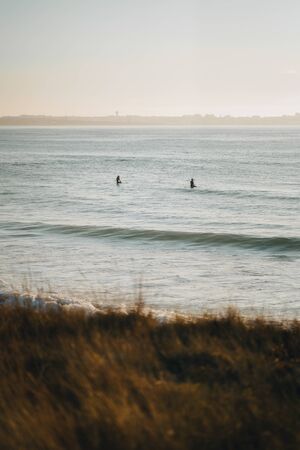 2 surfers waiting for the last waveの写真素材