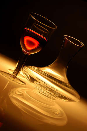 Single wine glass with red wine and glass decanter on a dark background with transparencyの写真素材