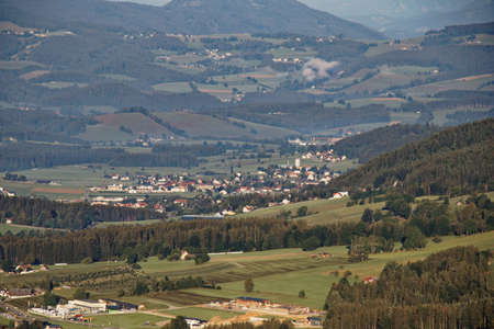 High angle view on a small town in an mountain valley surrouded by forests in summerの写真素材