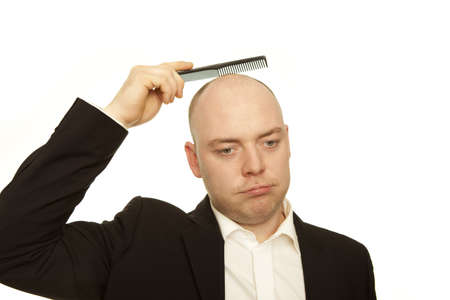 business man with comb is sad about hair lossの写真素材