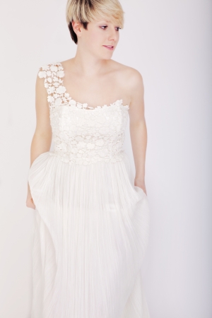 Stunning young blonde girl standing with bridal dressの写真素材