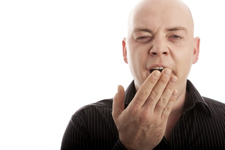 bald man on white background is tired and yawnの写真素材