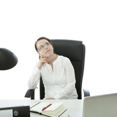 young brunette businesswoman with glasses is thinkingの写真素材