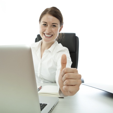 young brunette business woman thumb up on deskの写真素材