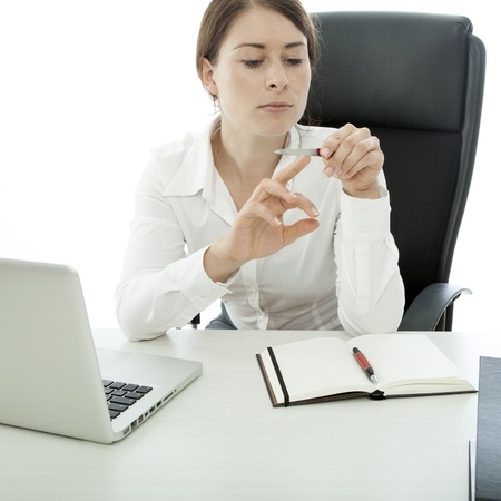 young brunette business woman file nails while workingの写真素材