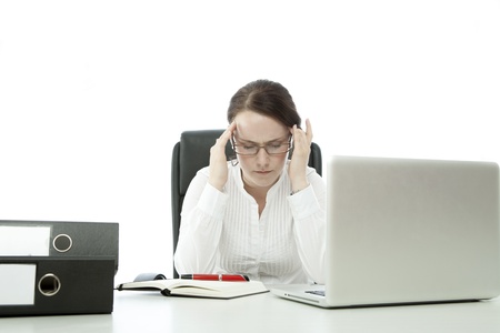 young brunette business woman with glasses has headache on deskの写真素材
