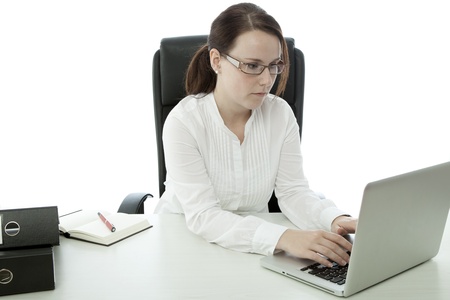 young brunette businesswoman with glasses working on laptopの写真素材