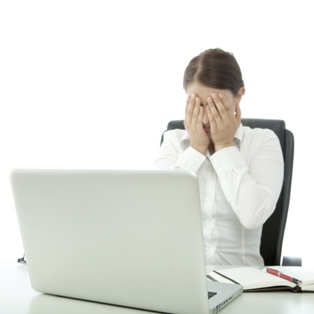 young beautiful brunette woman is depressed on deskの写真素材