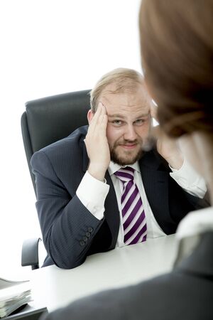 beard business man brunette woman at desk has headacheの写真素材