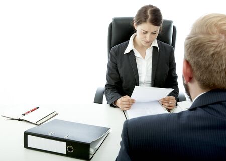 beard business man brunette woman at desk read applicationの写真素材