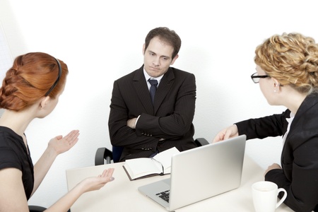 Two women try to explain a business proposal to an unimpressed man. Business meeting conceptの写真素材