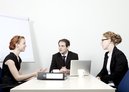 Successful attractive young business team having a meeting seated around a table having an animated discussion as they plan their future strategyの写真素材