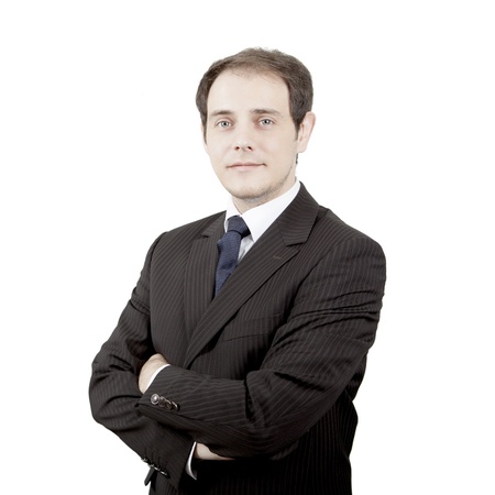 Caucasian young nostalgic businessman looking at camera with arms folded, portraitの写真素材
