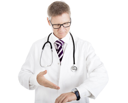 Middle-aged male doctor gesturing at his watch as he checks the time remaining before an appointment or meeting, isolated on whiteの写真素材