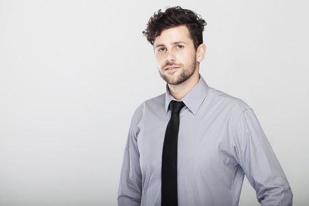 confident modern stylish young and trendy business man, pose in front of grey background.の写真素材