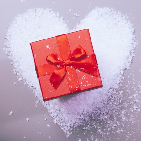 gift box on snow heartの写真素材