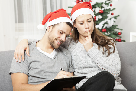 happy young couple think about to do list for christmas eve on sofaの写真素材