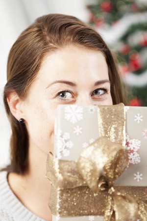 young girl hide behind christmas present boxの写真素材