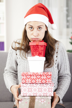 young girl has a lot of christmas gifts to give somebodyの写真素材