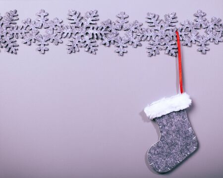Christmas sock hanging on snowflake pattern on clean background, vintage cool instagram filter lookの写真素材