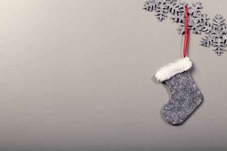 Christmas sock hanging on snowflake pattern on clean background, vintage cool filter lookの写真素材
