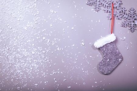 Christmas sock hanging on snowflake pattern on clean background, vintage cool filter lookの写真素材