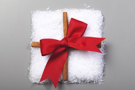 beautiful gift made from snow with red ribbon on grey backgroundの写真素材
