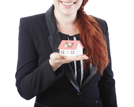 young beautiful business woman showing mini house in her hand, isolated on white backgroundの写真素材