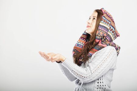 young pretty cute girl waiting for snow with hands open and looking up, isolated on grey backgroundの写真素材