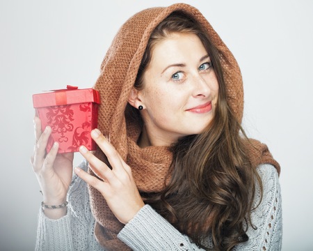 young happy playful cute winter girl with gift box and filter look with blur and bokeh, isolated on grey backgroundの写真素材