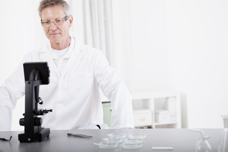 portrait of male medical or scientific researcher with microscope in a laboratoryの写真素材