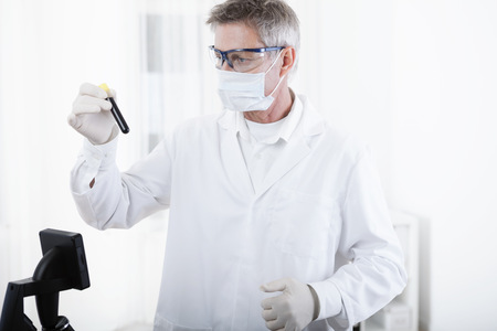 scientist or doctor working with microscope and blood, in lab or hospitalの写真素材